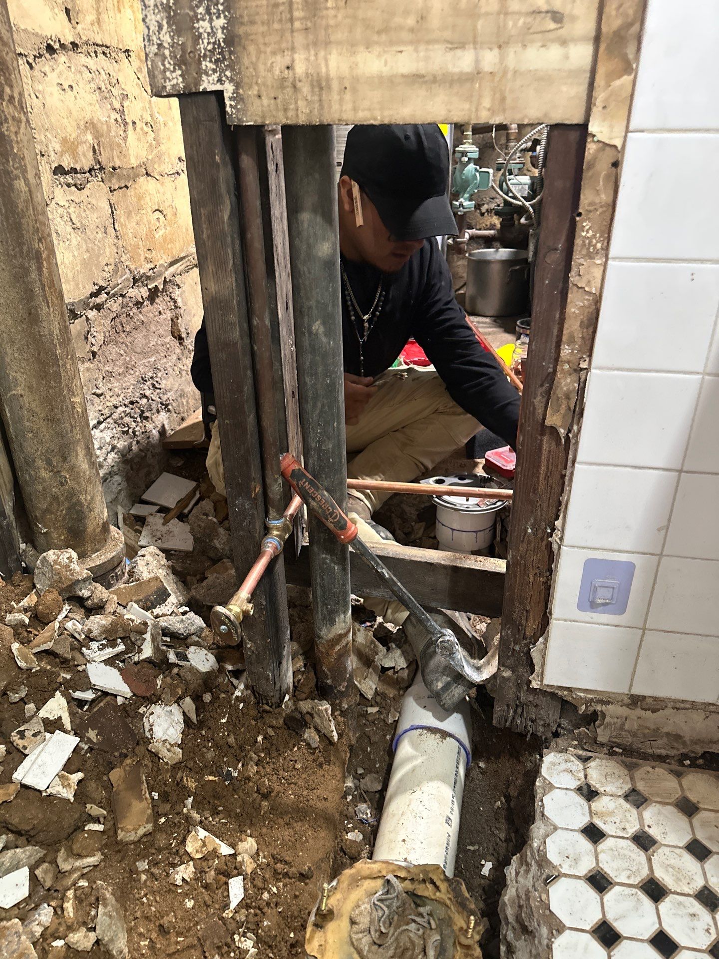 Technician repairing copper plumbing in wall
