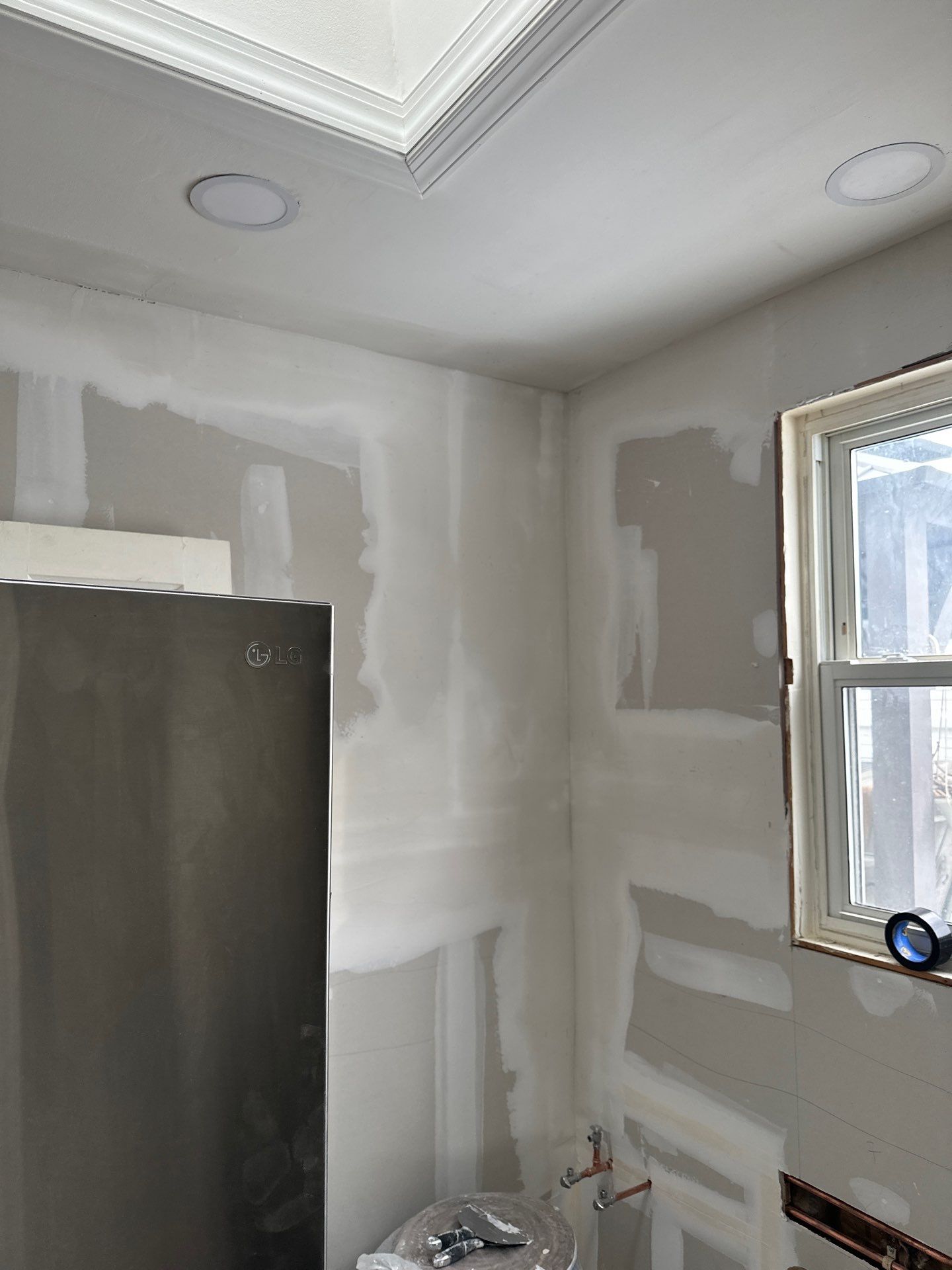 Newly taped and finished drywall with recessed lights