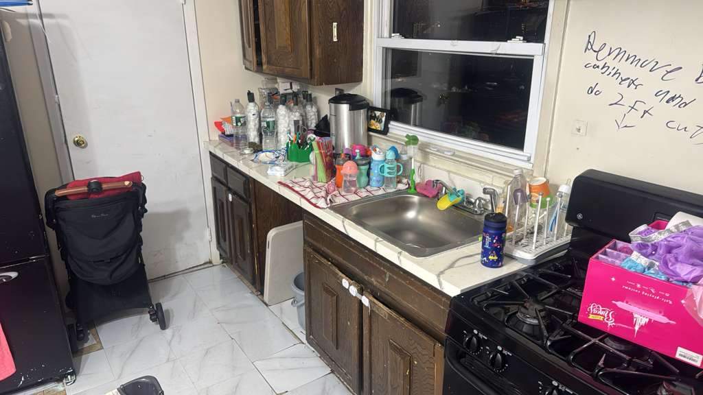 Cluttered family kitchen with dated dark cabinets before renovation