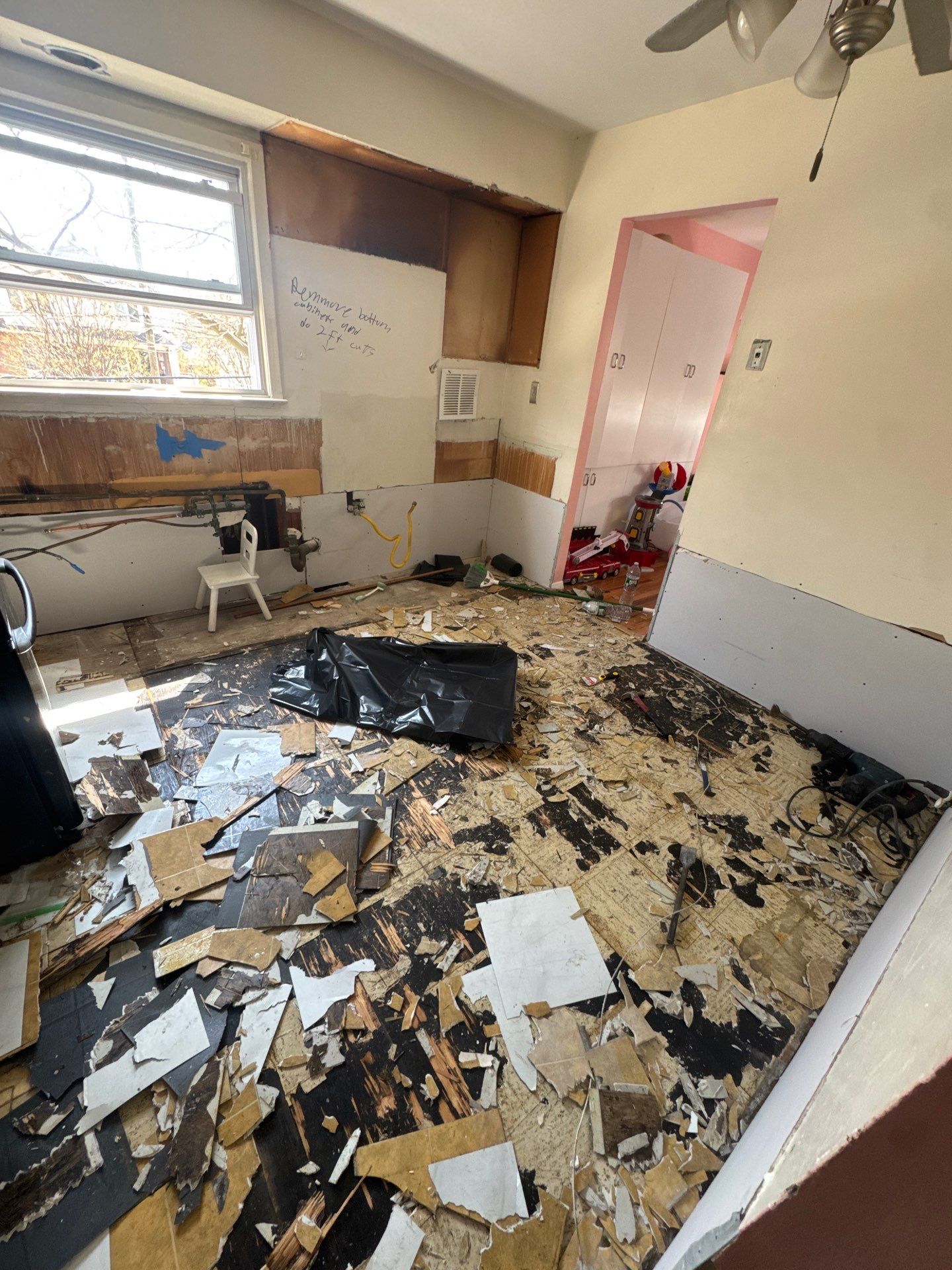Kitchen stripped down to subfloor with debris