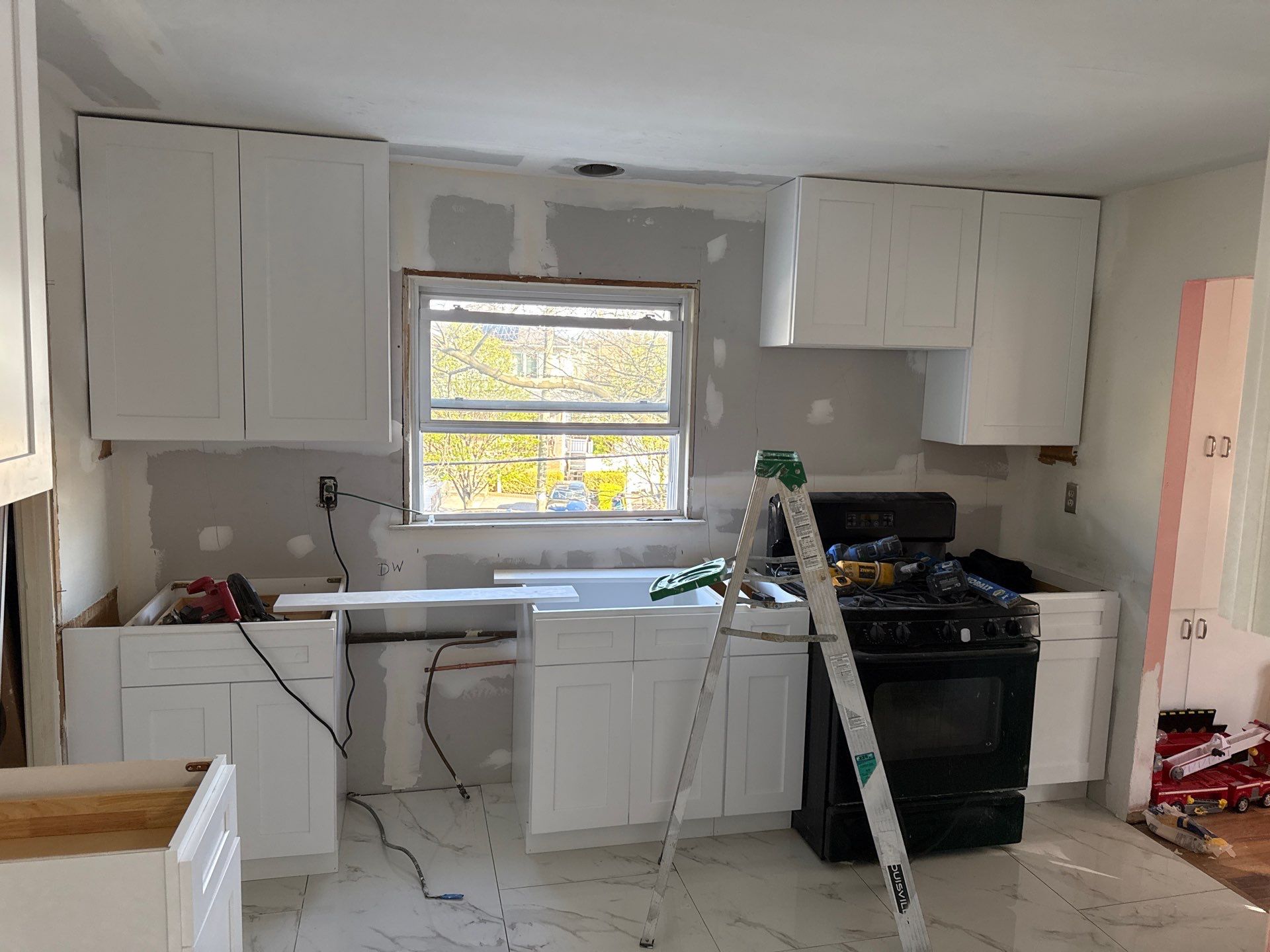 New white shaker cabinets installed, drywall patched