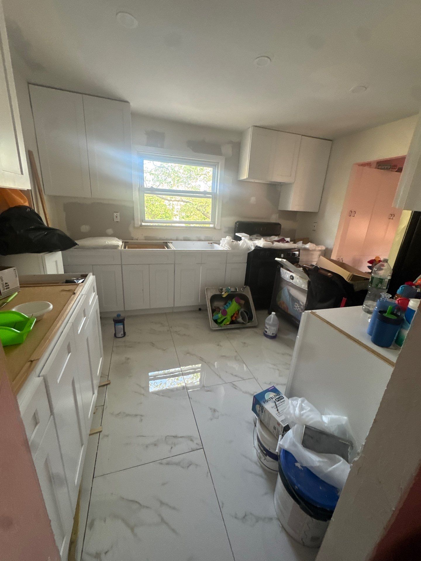 Nearly finished bright white kitchen with marble floor